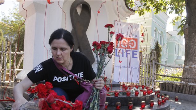 Mujer deposita flores en el monumento dedicado a las víctimas del Sida en Kiev, Ucrania, el 19 de mayo 2017.