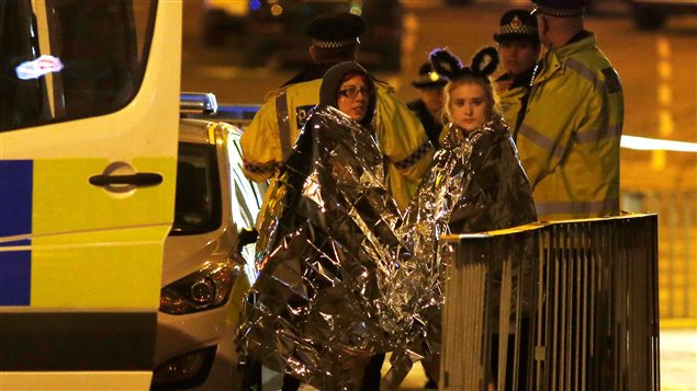 Two women wrapped in thermal blankets stand near the Manchester Arena, where U.S. singer Ariana Grande had been performing, in Manchester, northern England, Britain, May 23, 2017.