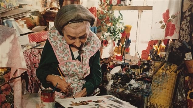 Maud Lewis painting in her home in spite of arthritis