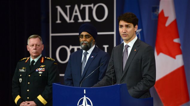 Prime Minister Justin Trudeau, right to left, is flanked by Canada's minister of defence and the chief of defence staff at a news conference at NATO headquarters in Brussels, Belgium.