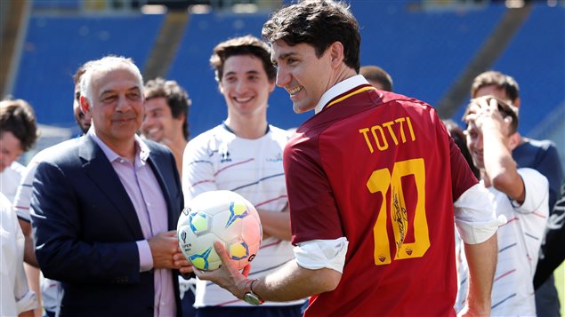 رئيس الحكومة الكندية جوستان ترودو مرتدياً قميص لاعب كرة القدم الإيطالي فرانشيسكو توتي، التي تحمل توقيع هذا الأخير، خلال مباراة كرة القدم التي رعاها أمس في استاد روما الأولمبي.  