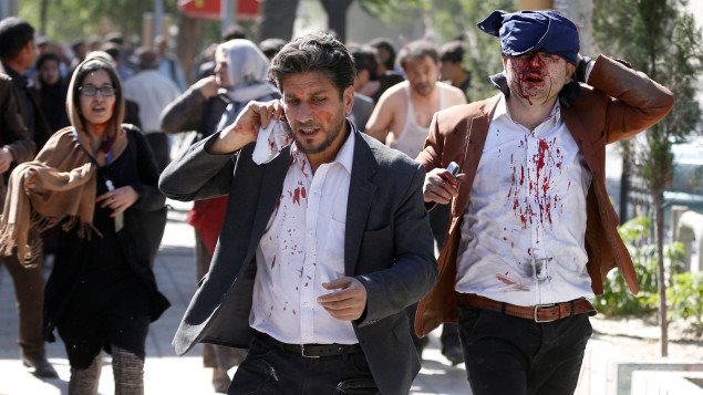 Injured Afghans run from the site of a blast in Kabul. REUTERS/Omar Sobhani