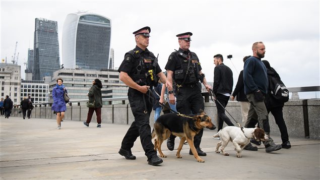 Policías inlgeses con perros patrullan este lunes el Puente de Londres, después del atentado que dejó 7 muertos y 48 heridos. 