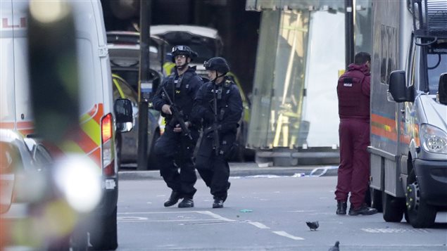 Police patrol a cordoned off area after terrorists killed 7 people and wounded 48 in London.