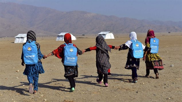 Afghan schoolgirls hold hands and walk towards their tent classrooms on the outskirts of Jalalabad, capital of Nangarhar province, Afghanistan, Tuesday, Dec. 13, 2016.