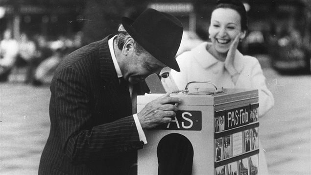 Armenian born Canadian portrait photographer Yousuf Karsh (1908 - 2002) trying out a Danish street photographer’s camera in Copenhagen. With him is his second wife, Estrellita.