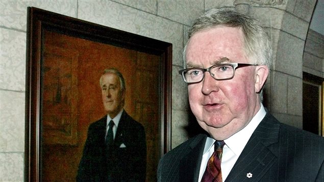 Former Progressive Conservative leader Joe Clark walks past a portrait of former Canadian Prime Minister Brian Mulroney, on Parliament Hill in Ottawa, April 26, 2004.