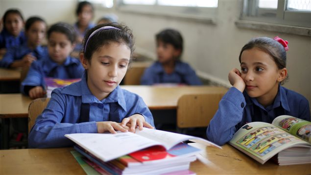 طالبات تلقين كتبهن الجديدة في أول يوم من العام الدراسي في مدرسة تابعة للأونروا في مخيم الوحدات للاجئين الفلسطينيين في العاصمة الأردنية عمّان في الأول من أيلول (سبتمبر) 2016