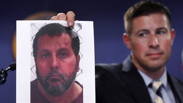 Timothy Wiley, FBI public affairs specialist, holds a photo Amor Ftouhi after a news conference in Detroit, Thursday, June 22, 2017. 