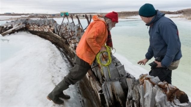  2015: close-up of the starboard side of Maud showing through the ice with members of the Norwegian *Maud Returns Home* organisation.