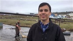 Andrew Scott Medeiros, a then Assistant Professor in the Department of Geography at York University is part of a research team that has been coming to Iqaluit for a decade to test the water quality. In the background Michael Bakaic, a graduate student from York collects samples to test. 