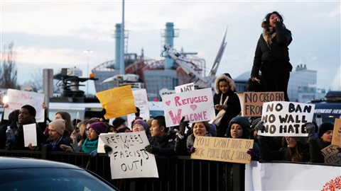 Des manifestants rassemblés le 29 janvier dernier devant l’aéroport international John F. Kennedy, de New York, afin de protester contre les décrets anti-immigration du président des États-Unis, Donald Trump. Photo : La Presse canadienne/Associated Press/Seth Wenig