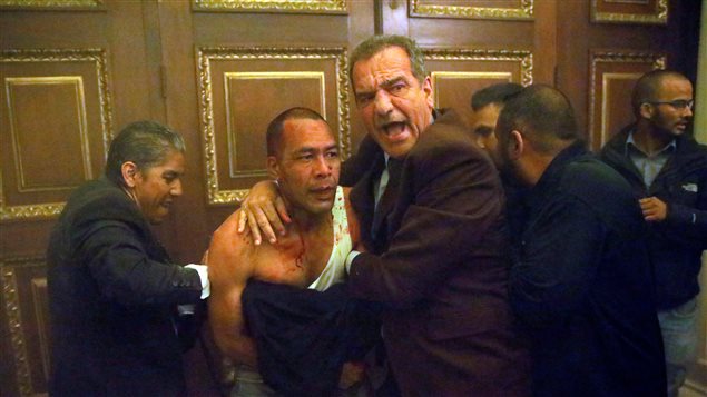 Opposition lawmaker Luis Stefanelli (R) reacts while holding an injured government supporter after he and a group of fellow government supporters burst into Venezuela’s opposition-controlled National Assembly during a session, in Caracas.