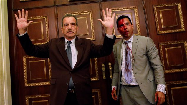 Opposition lawmaker Luis Stefanelli gestures next to fellow opposition lawmaker Leonardo Regnault after a group of government supporters burst into Venezuela’s opposition-controlled National Assembly during a session, in Caracas.