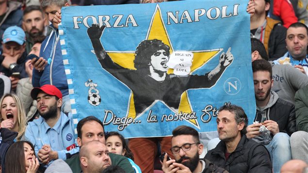 Aficionado del Napoli, con una bandera que muestra a Maradona, en un partido de semifinal entre el SSC Napoli y el Juventus FC, el 5 de abril del 2017 en el Estadio San Paolo, de Napoles. 