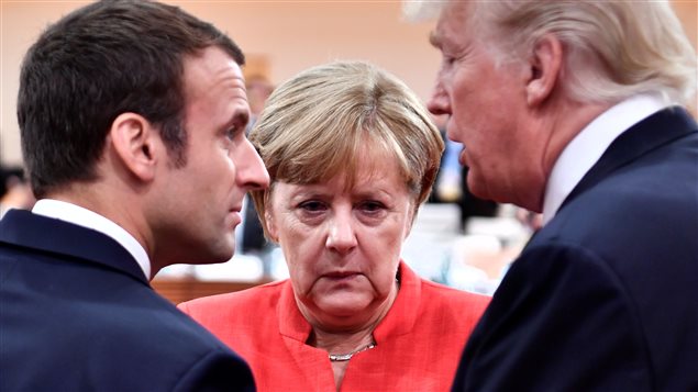 French President Emmanuel Macron, German Chancellor Angela Merkel and U.S. President Donald Trump confer at the start of the first working session of the G20 meeting in Hamburg, Germany, July 7, 2017.