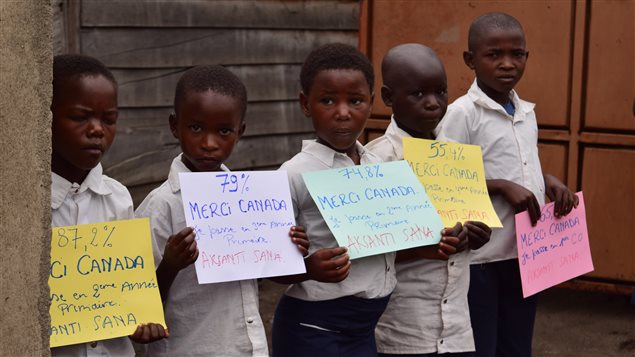 Congolese children display signs saying *Thank you Canada* during the visit of federal International Development Minister Marie-Claude Bibeau in July 2017.