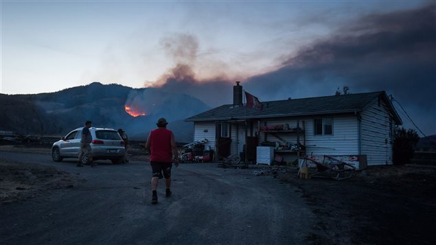 Un poblador retorna a su vivienda para intentar recuperar algunos bienes, ante la amenaza del fuego.