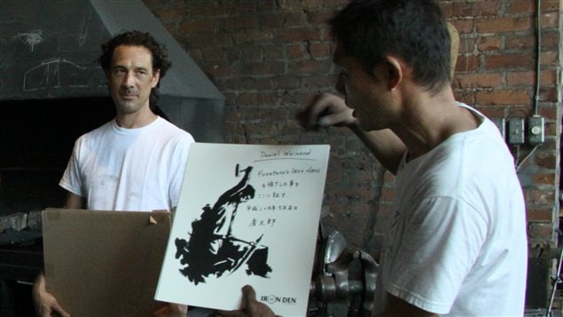 Montreal blademaker Allen Rozon (left) watches as master Japanese swordsmith hands out certificates to students who completed a blademaking workshop at Les Forges de Montreal on July 5, 2017.