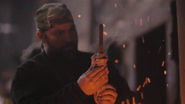 A still image taken from a promotional video by Iron Den Forge of a blade-making workshop organized by Allen Rozon and master Japanese swordsmith Fusataro.