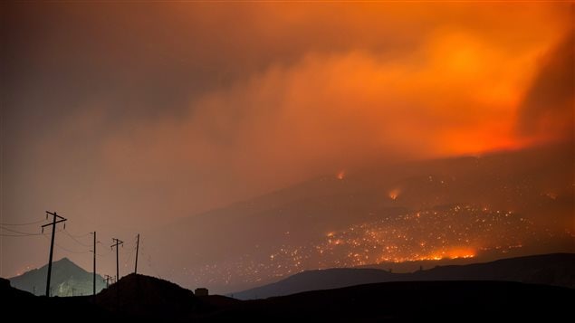 A wildfire burns on a mountain in the distance east of Cache Creek, B.C., in the early morning hours of Monday July 10, 2017.