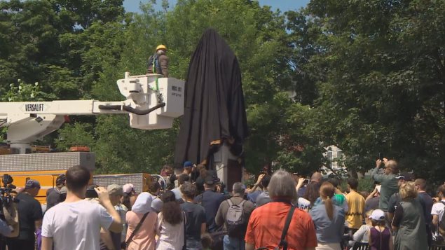 Halifax city workers cover the statue on the weekend to calm protesters who threatened to pull it down.