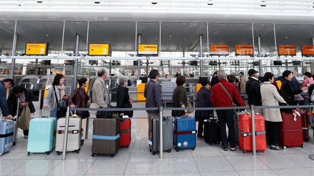 Passengers await their check-in for German airline Lufthansa at Munich airport October 20, 2014. Canada now requires pre-registry via an *eTA*, but it only costs the equivalent of $7, anything more and you’re likely being scammed by a *fake* site.