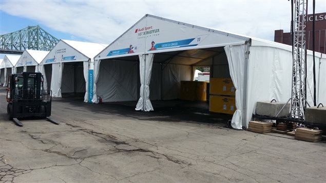 The paddock area in the parking lot of the Radio-Canada/CBC building, with team names and photos of drivers on each tent.