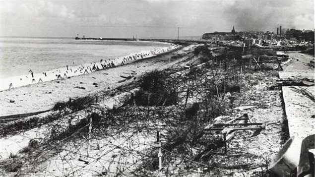 The concrete barriers, wire fencing, and other obstacles on the beach show how well the Germans fortified the Dieppe beach. British intelligence about beach conditions and defences failed miserably leading to the catasophe.