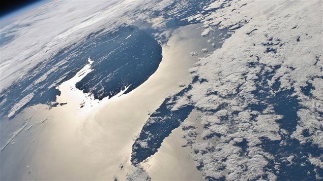 This high-oblique view of the Gaspe Peninsula and Anticosti Island with sun glint on the Gulf of St. Lawrence and Chaleur Bay, Canada, was photographed by an Expedition 24 crew member on the International Space Station.