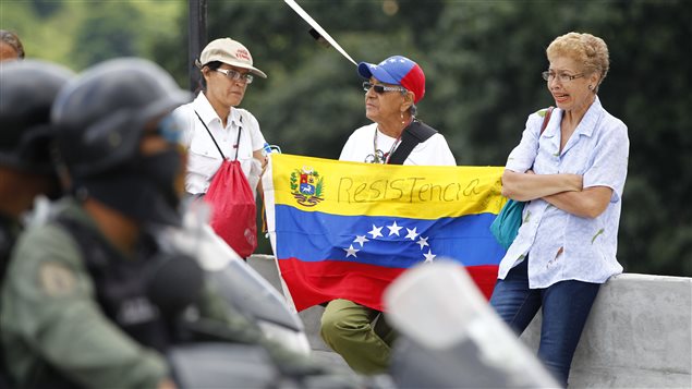 Opposition supporters hold a national flag with the word *Resistance* written on it as they face members of the National Guard as the Constituent Assembly election was being carried out in Caracas, Venezuela, July 30, 2017.