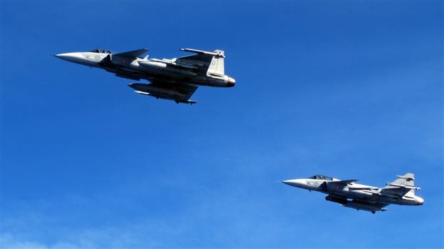 Saab JAS 39C Gripen fighter jets from F17 Wing of the Swedish Air Force demonstrate a mid-air interception over Sweden during a press tour of Swedish air and naval facilities on April 28, 2015.