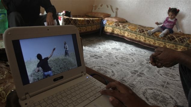 Video of an incident filmed on Saturday by Ibrahim Makhlouf (not pictured) is displayed by his son in the West Bank village of Aseera al-Qibliya village near Nablus May 22, 2012. Amateur video, filmed by Makhlouf, of Israeli soldiers appearing to watch idly as settlers opened fire on Palestinians throwing stones has emphasised the growing power of *citizen journalism* in the occupied West Bank.