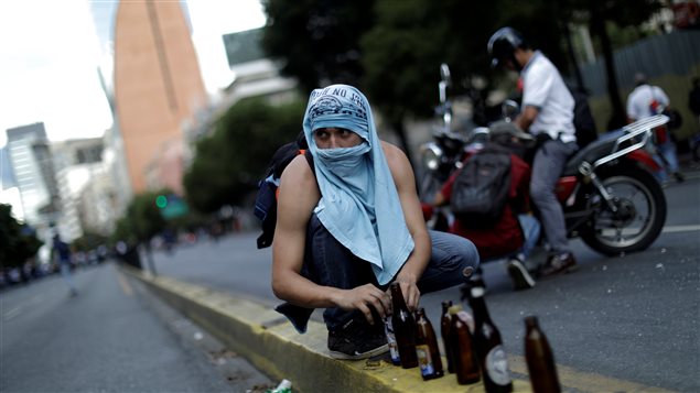 Un manifestante de la oposición en Caracas alista sus cocteles molotov