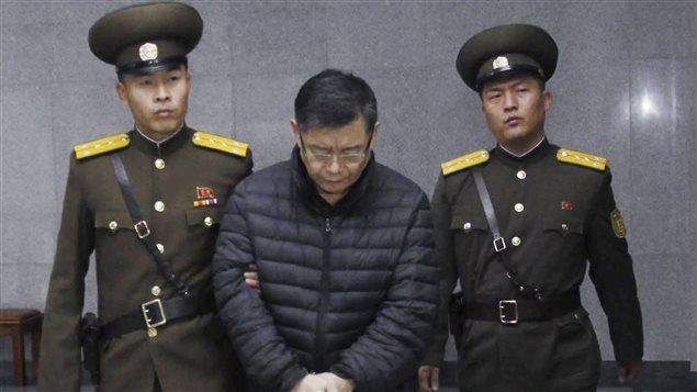 El pastor de Mississauga, Hyeon Soo Lim es escoltado por dos guardias norcoreanos.