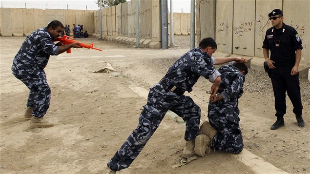 A member of the Italian Carabinieri (R) supervises oil police cadets during a training course at Camp Dublin in Baghdad May 15, 2011. 