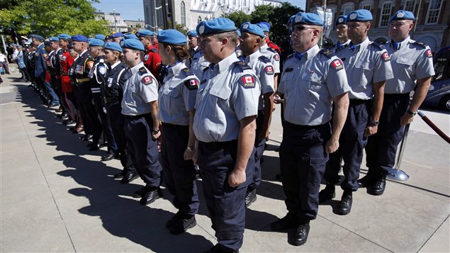 A contingent of police officers training to deploy to Haiti for a year stand at attention at the National Peacekeeping Monument on National Peacekeepers Day in Ottawa on Sunday, August 11, 2013.