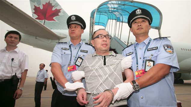 Déporté du Canada, Lai Changxing est arrêté par la police chinoise à son arrivée à Pékin. Photo : Reuters/China Stringer Network