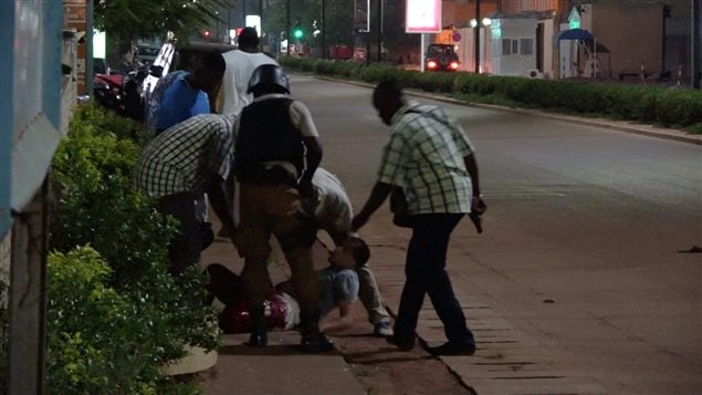 A wounded unidentified person is evacuated following an attack by gunmen on a restaurant in Ouagadougou, Burkina Faso, in this still frame taken from video August 13, 2017. 