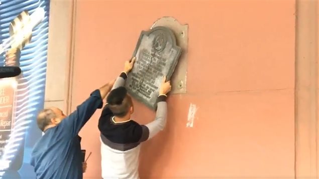 Workers removed a plaque commemorating Confederate States President Jefferson Davis outside the Hudson’s Bay Company flagship store in downtown Montreal on Tuesday. (Sarah Leavitt/CBC)