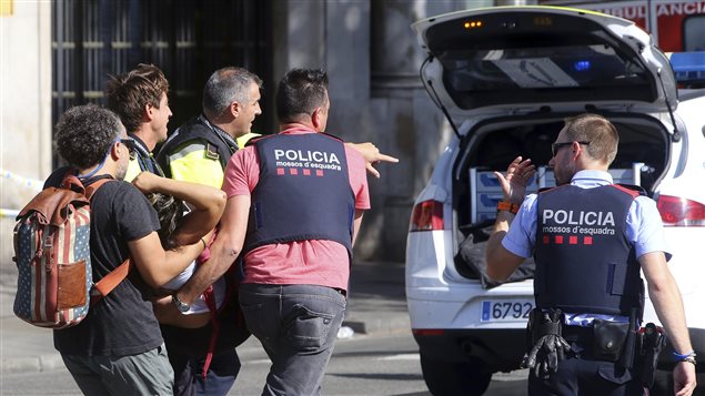 An injured person is carried in Barcelona, Spain, Thursday, Aug. 17, 2017, after a white van jumped the sidewalk in the historic Las Ramblas district, crashing into a summer crowd of residents and tourists and injuring several people, police said. 