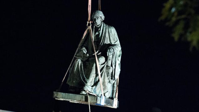 Utilizando grúas, un equipo de obreros arrancó de su pedestal la estatua del juez Roger Taney.