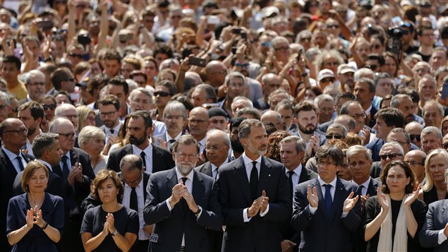 King Felipe of Spain, fourth from left, and Prime Minister Mariano Rajoy, third from left, join people gathered for a minute of silence in memory of the terrorist attacks victims in Las Ramblas, Barcelona, Spain, Friday, Aug. 18, 2017. 