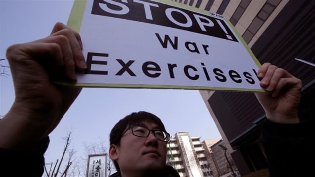 Un manifestante surcoreano sostiene una pancarta denunciando los ejercicios militares entre  Estados Unidos y Corea del Sur. 
