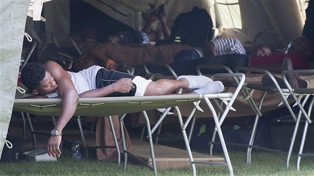 Asylum seekers rest in a tent at the Canada-United States border in Lacolle, Que., Thursday, August 10, 2017.