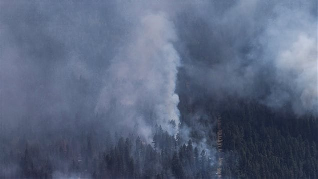 A wildfire is seen from a Canadian Forces Chinook helicopter as Prime Minister Justin Trudeau views areas affected by wildfire near Williams Lake, B.C., on Monday July 31, 2017. British Columbia is facing its worst wildfire season as flames scorch more than one million hectares of land and costs rise to deal with the devastation.