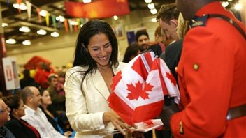 Une jeune femme heureuse d’avoir obtenu la citoyenneté canadienne lors d’une cérémonie à Halifax, en octobre 2010. Photo : MARKETWIRE PHOTO/Government of Canada