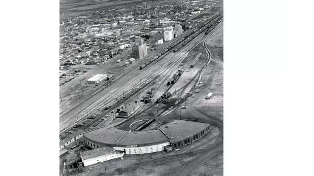 Possibly circa 1960’s: The historic CNR roundhouse at Hanna, showing the five bay brick addition, torn down in 2012. Also shown are several grain elevators along the main track lines. These once vital structures, the ’castles* of the prairies, are gone now as well.