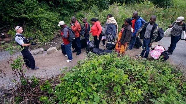 A Royal Canadian Mounted Police officer informs migrants of their rights at the Saint-Bernard-de-Lacolle border, Aug. 7, 2017. Many people say if the border isn’t sealed, Canada could be overwhelmed by asylum seekers. There are about 12 million *illegals* in the U.S. Guidy Mamann says, Canadian’s generosity could end up turning to animosity againsst all asylum seekers, including legitimate refugees.