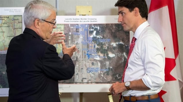 Prime Minister Justin Trudeau (right) received a briefing on the refugee installations at the Lacolle border crossing by Transport Minister Marc Garneau before meeting with the Intergovernmental Task Force on Irregular Migration on Aug 23/17. Many people say it was Trudeau’s tweet that Canada welcomes everyone that caused the spike in illegal crossing and asylum claims. 